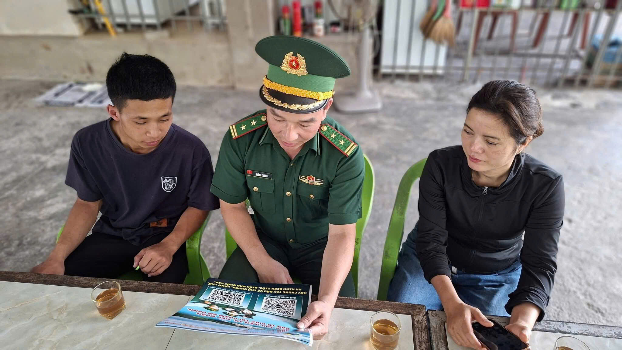 Cán bộ đến từng hộ hướng dẫn sử dụng quét mã QR.