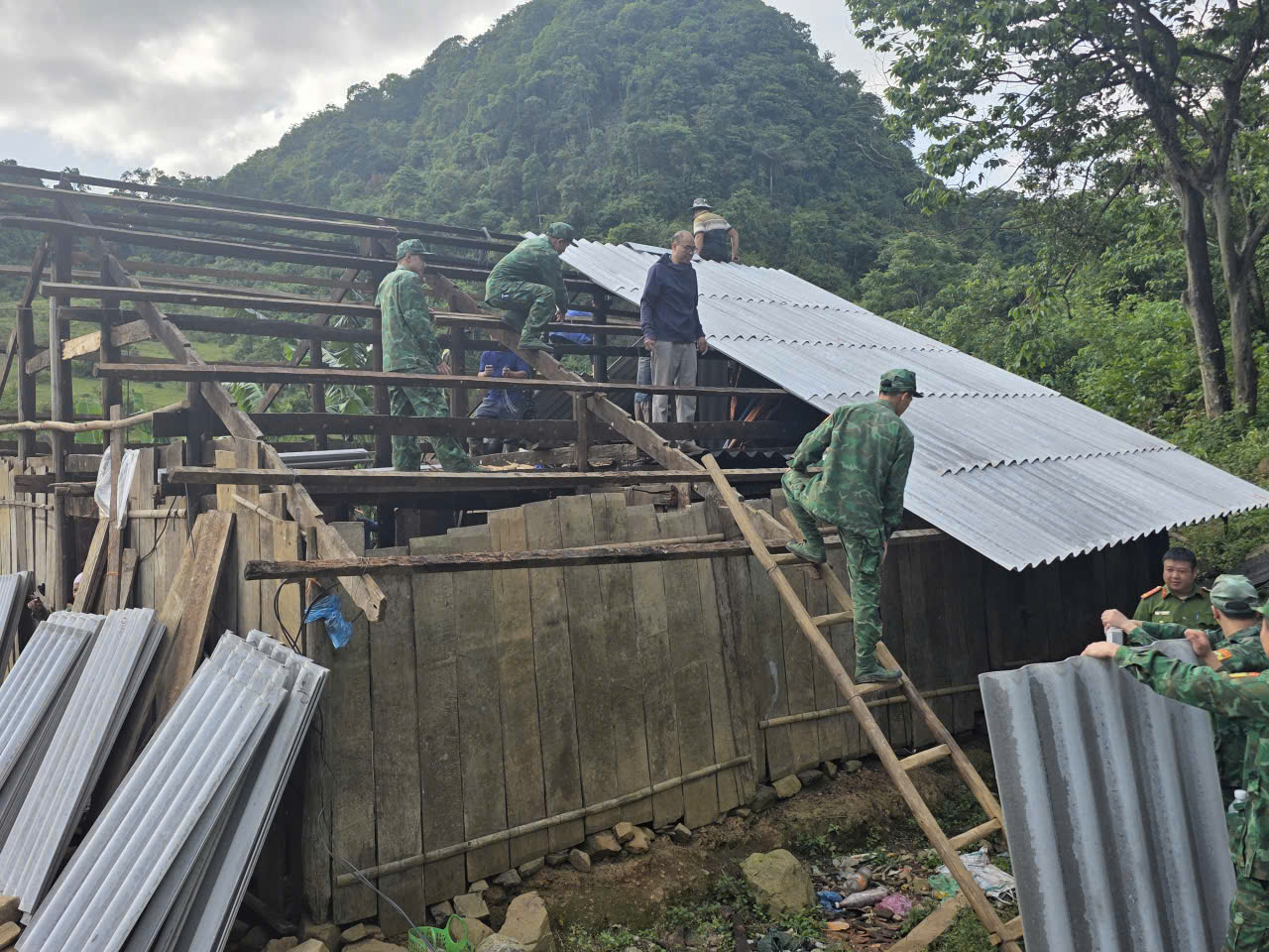 Các chiến sĩ khẩn trương lợp lại mái nhà cho bà con Nhân dân.