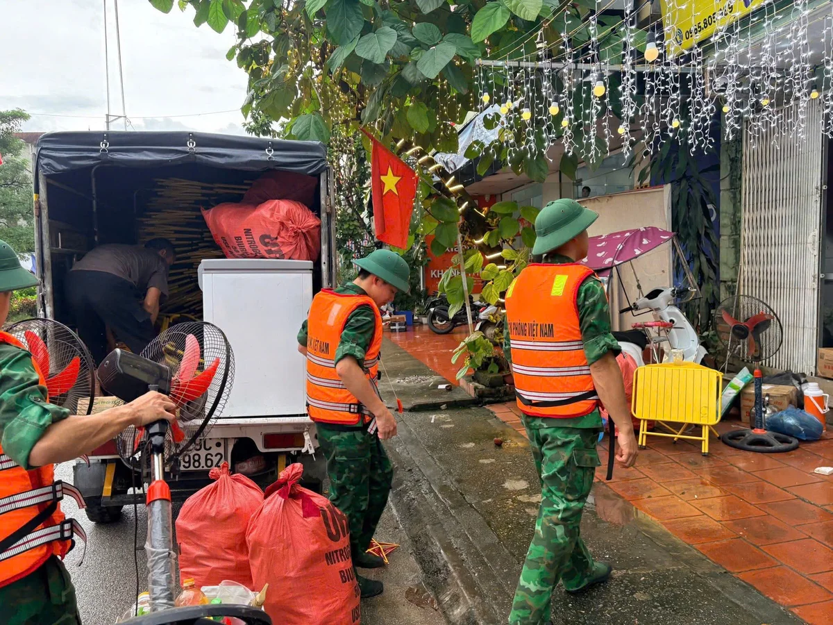 Bộ đội biên phòng giúp đỡ chuyển đồ cho người dân về ổn định cuộc sống.