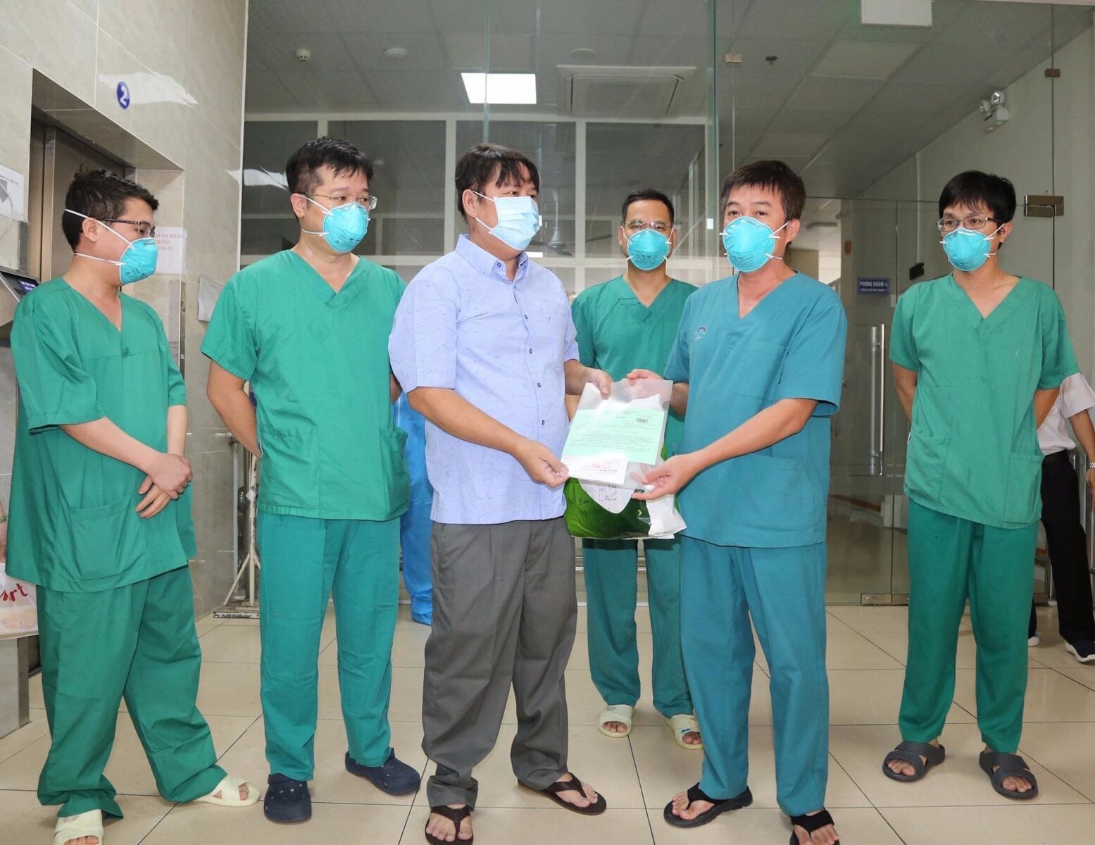 Bác sĩ Trần Thanh Linh - Phó khoa hồi sức cấp cứu bệnh viện Chợ Rẫy - trao giấy xuất viện cho chiến sĩ công an quận Tân Phú (ảnh: bệnh viện cung cấp)