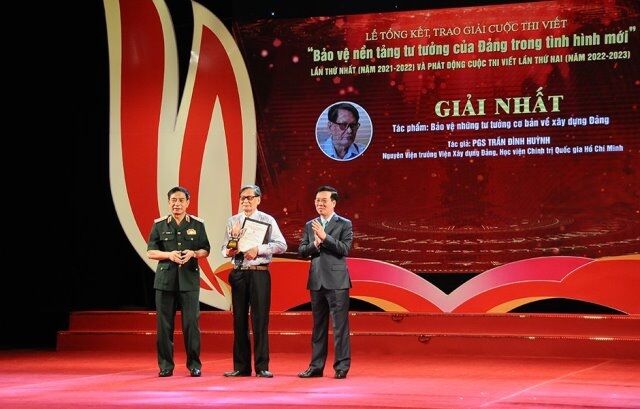 Đồng chí Võ Văn Thưởng - Ủy viên Bộ Chính trị, Thường trực Ban Bí thư và Đại tướng Phan Văn Giang - Ủy viên Bộ Chính trị, Phó Bí thư Quân ủy Trung ương, Bộ trưởng Bộ Quốc phòng trao giải Nhất cho PGS, TS Trần Đình Huỳnh, nguyên Viện trưởng Viện Xây dựng Đảng.