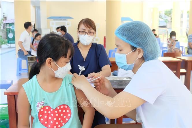 Tiêm vaccine phòng COVID-19 để trẻ đến trường an toàn. (Ảnh: TTXVN)