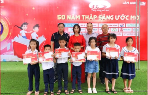 Đại diện Điện Quang và các NPP trao học bổng cho các em học sinh