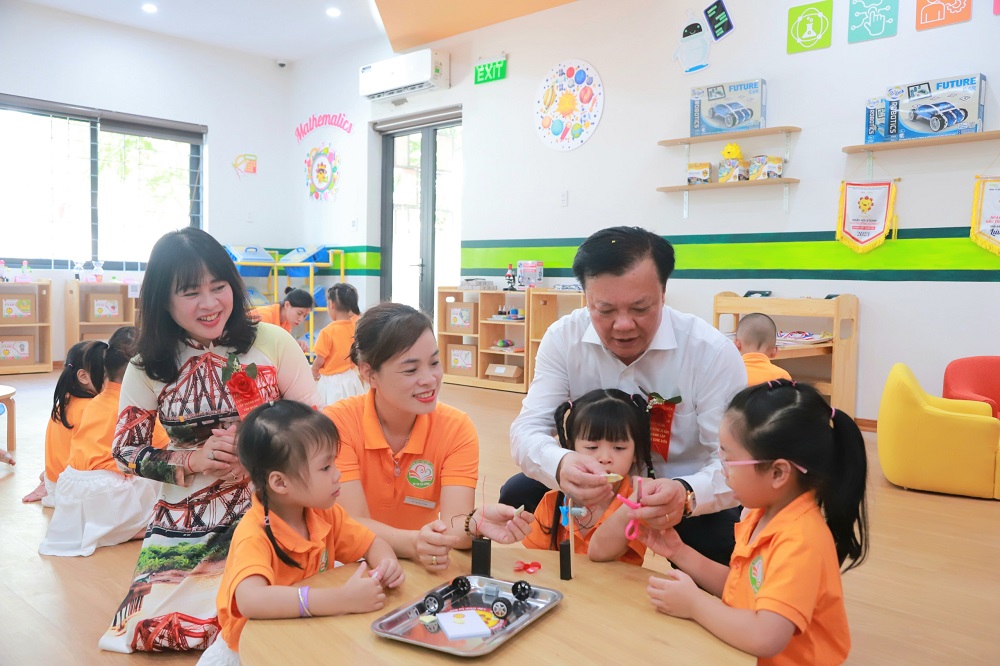 Bí thư Thành ủy Hà Nội Đinh Tiến Dũng cùng các em học sinh lắp ráp mô hình rô bốt tại lớp học sáng tạo, Trường Mầm non đô thị Sài Đồng