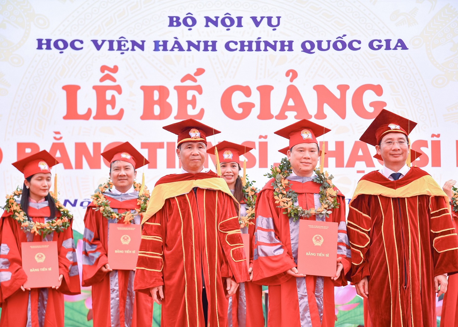 Thứ trưởng Bộ Nội vụ Triệu Văn Cường (bên trái) và Giám đốc Học viện Hành chính Quốc gia (bên phải) trao bằng cho Tân Tiến sĩ tại Lễ bế giảng.