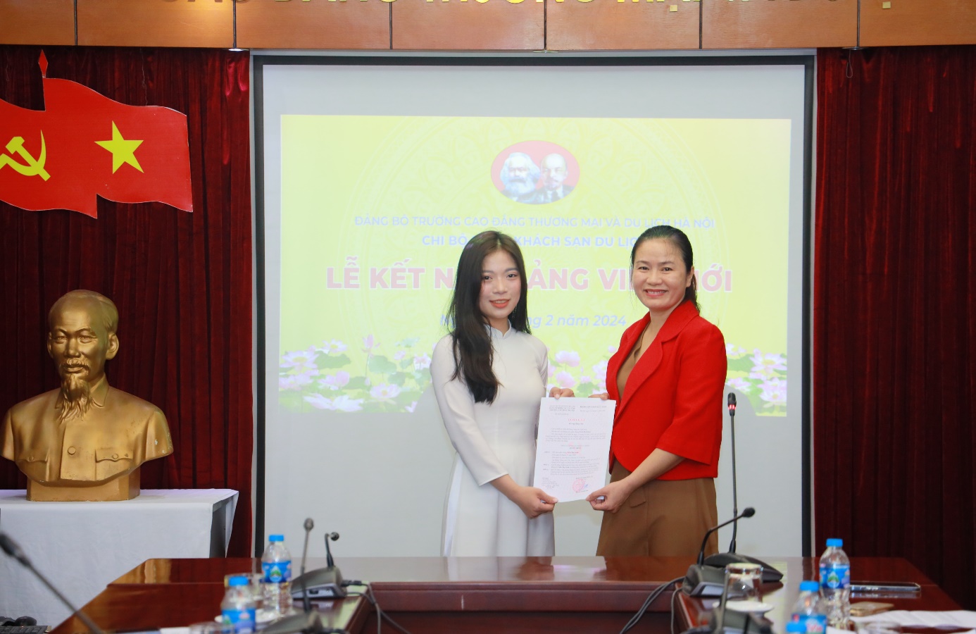 Đồng chí Nguyễn Thị Hồng Ngọc, Bí thư chi bộ Khoa Khách sạn Du lịch trao Quyết định kết nạp Đảng viên cho đồng chí Trần Thị Lành, sinh viên của khoa.