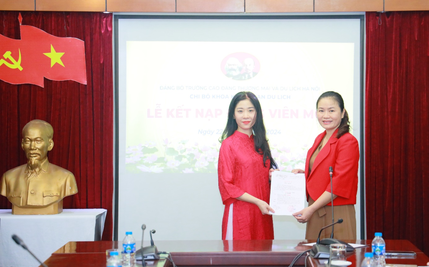 Đồng chí Nguyễn Thị Hồng Ngọc, Bí thư chi bộ Khoa Khách sạn Du lịch trao Quyết định kết nạp Đảng viên cho đồng chí Kiều Mai Hương, giảng viên của khoa.