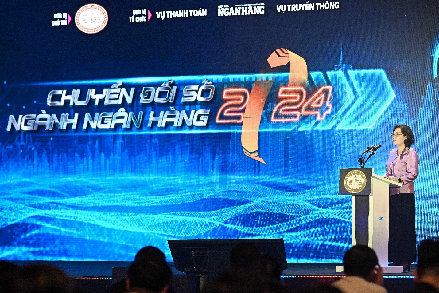 A person standing in front of a large screen

Description automatically generated