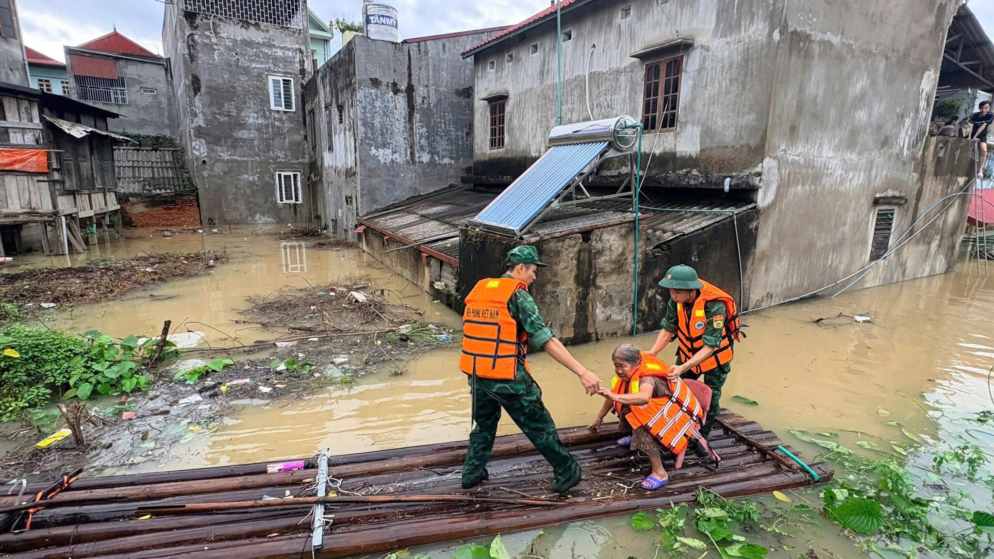 Lực lượng biên phòng ứng cứu người dân khỏi vùng lũ đưa về nơi an toàn.