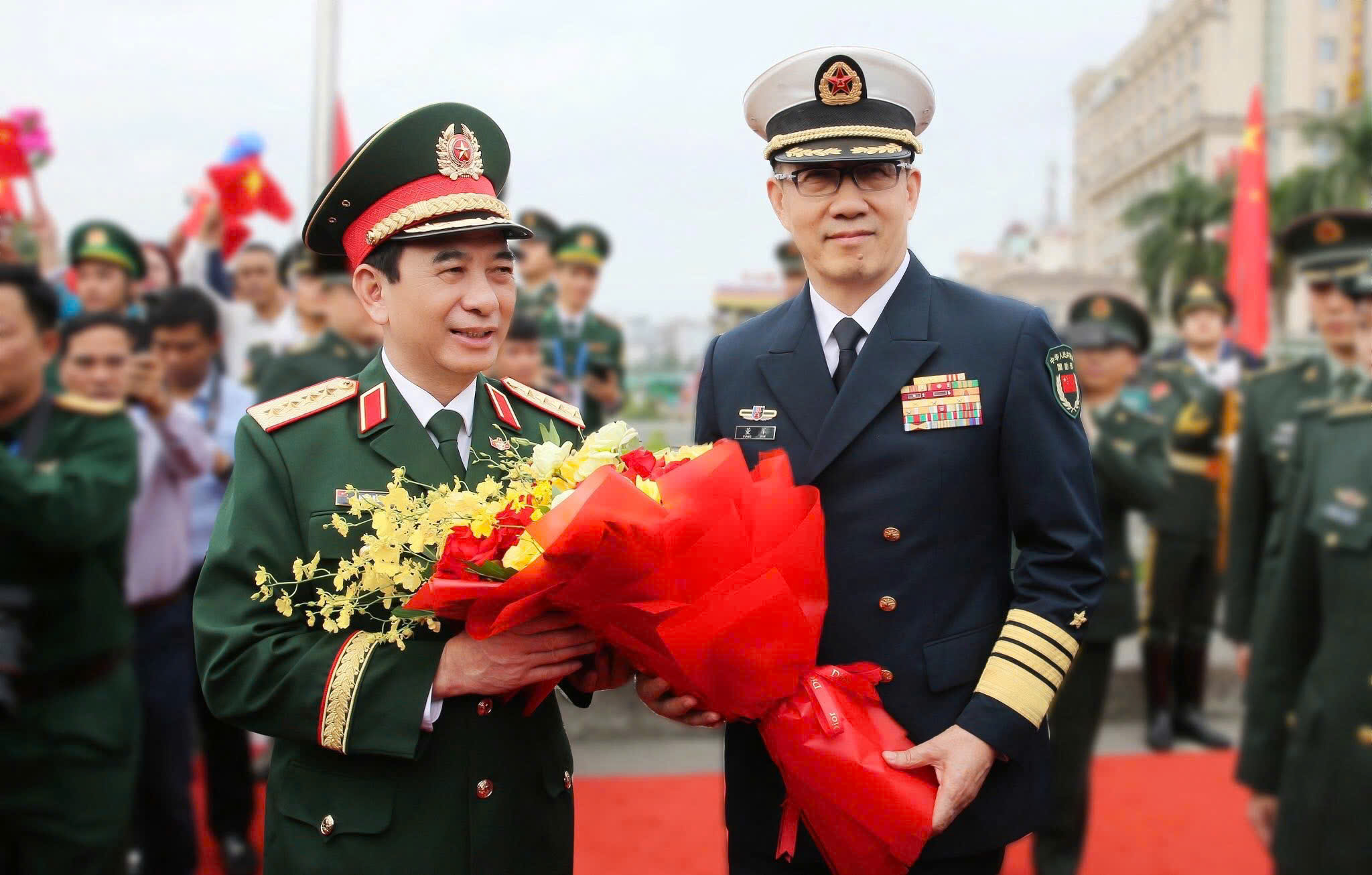 Đồng chí Đại tướng Phan Văn Giang, Ủy viên Bộ Chính trị, Bộ trưởng Bộ Quốc phòng Việt Nam cùng đoàn đại biểu cấp cao, đón đoàn đại biểu cấp cao Bộ Quốc phòng Trung Quốc do Thượng tướng Đổng Quân, Bộ trưởng Bộ Quốc phòng Trung Quốc dẫn đầu và tặng hoa.